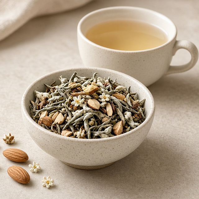 Da LBI Tea Know by Heart orange blossom almond white tea, loose leaf tea in a bowl with almonds and blossoms beside a cup of tea