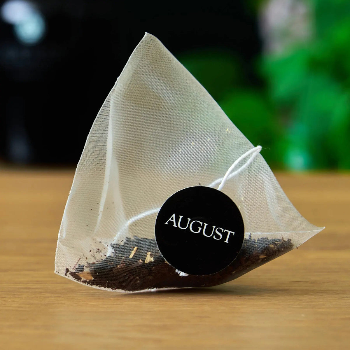 Close-up of a Jet Black pyramid tea bag filled with black tea and roasted coffee, Da LBI Tea