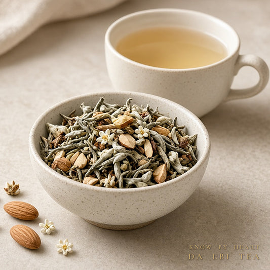 Da LBI Tea Know by Heart orange blossom almond white tea, loose leaf tea in a bowl with almonds and blossoms beside a cup of tea